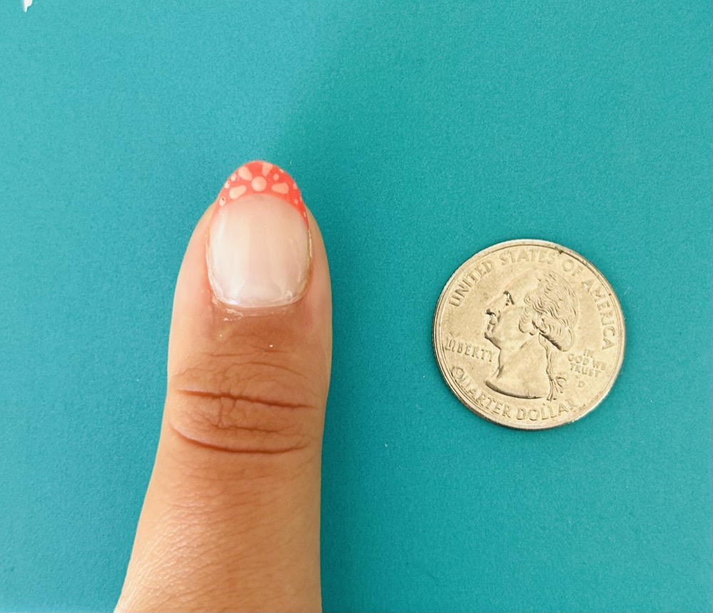 Example hand photo showing a fingernail placed next to a quarter for size reference